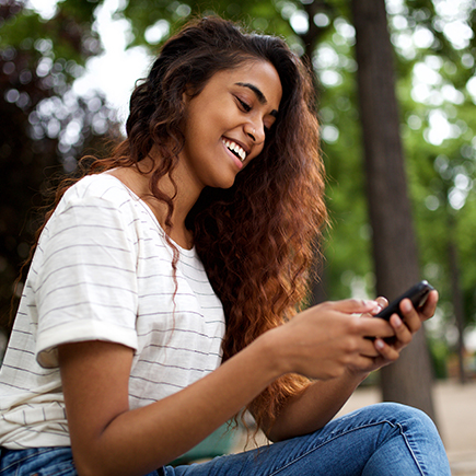 Woman sitting outside on her phone