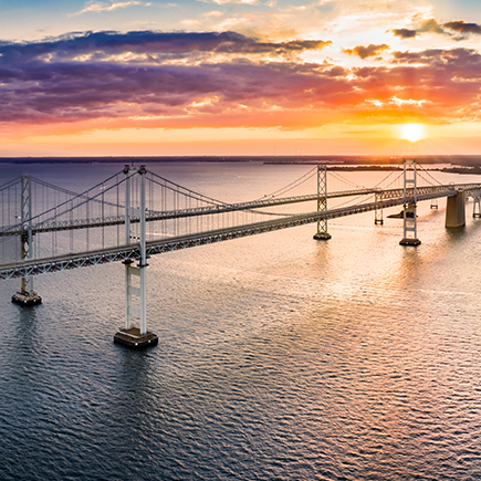 Sunset behind two bridges over water