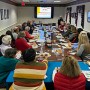 Board room filled with people viewing a presentation