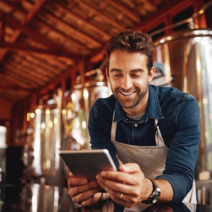 Man in a brewery looking at a tablet