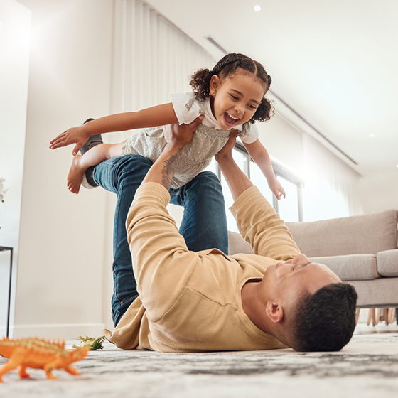 father and daughter playing on the living room floor 